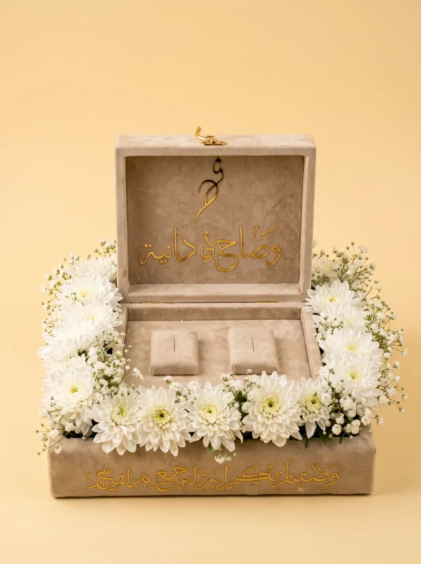 Cool couple presents: open velvet ring box with gold names and two ring pillows in white chrysanthemums