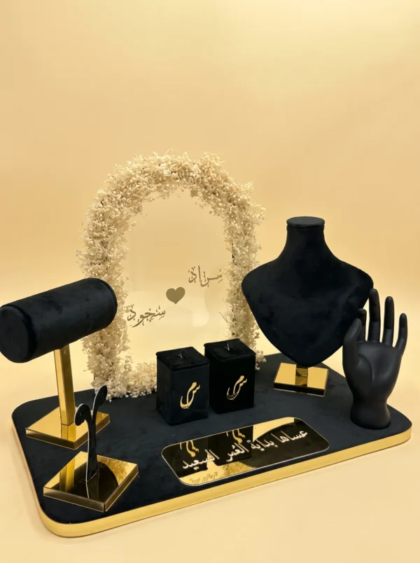 Couple ideas gifts: black velvet jewelry tray with gold stands, ring boxes and Arabic names under a floral arch