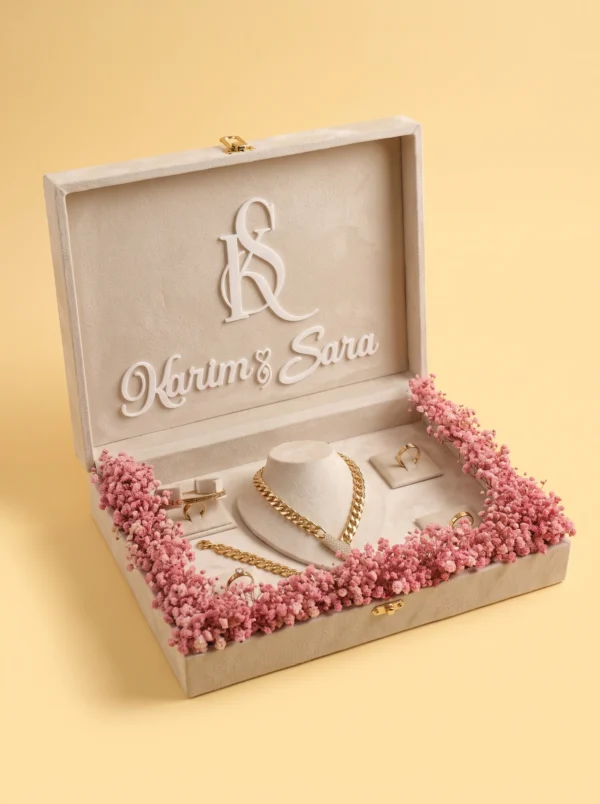 Wedding gifts: velvet box with gold curb chain on the stand, rings and first names in the lid