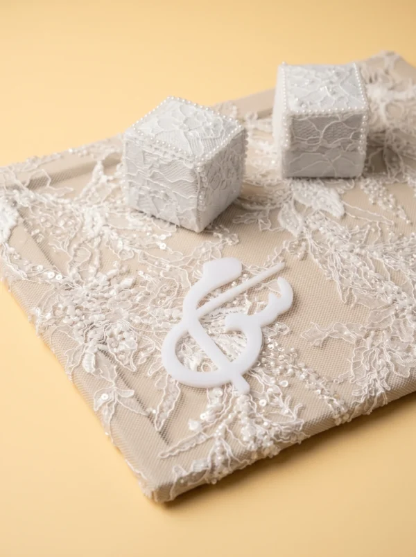 Idée cadeau marié : boîtes à bagues en dentelle bordées de perles et monogramme blanc sur plateau