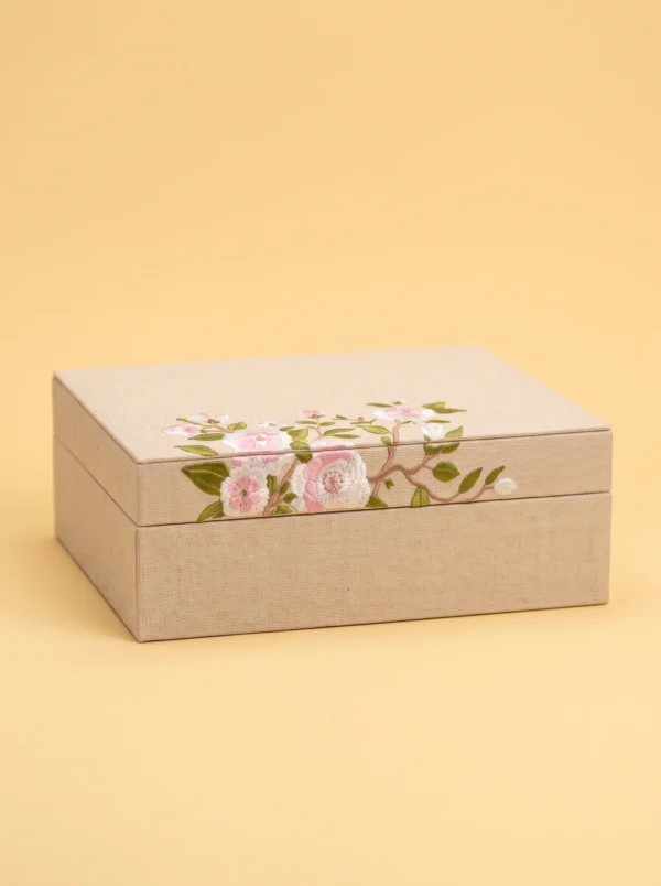 Ring boxes collection: closed linen box with embroidered pink roses and blossom branches on the lid